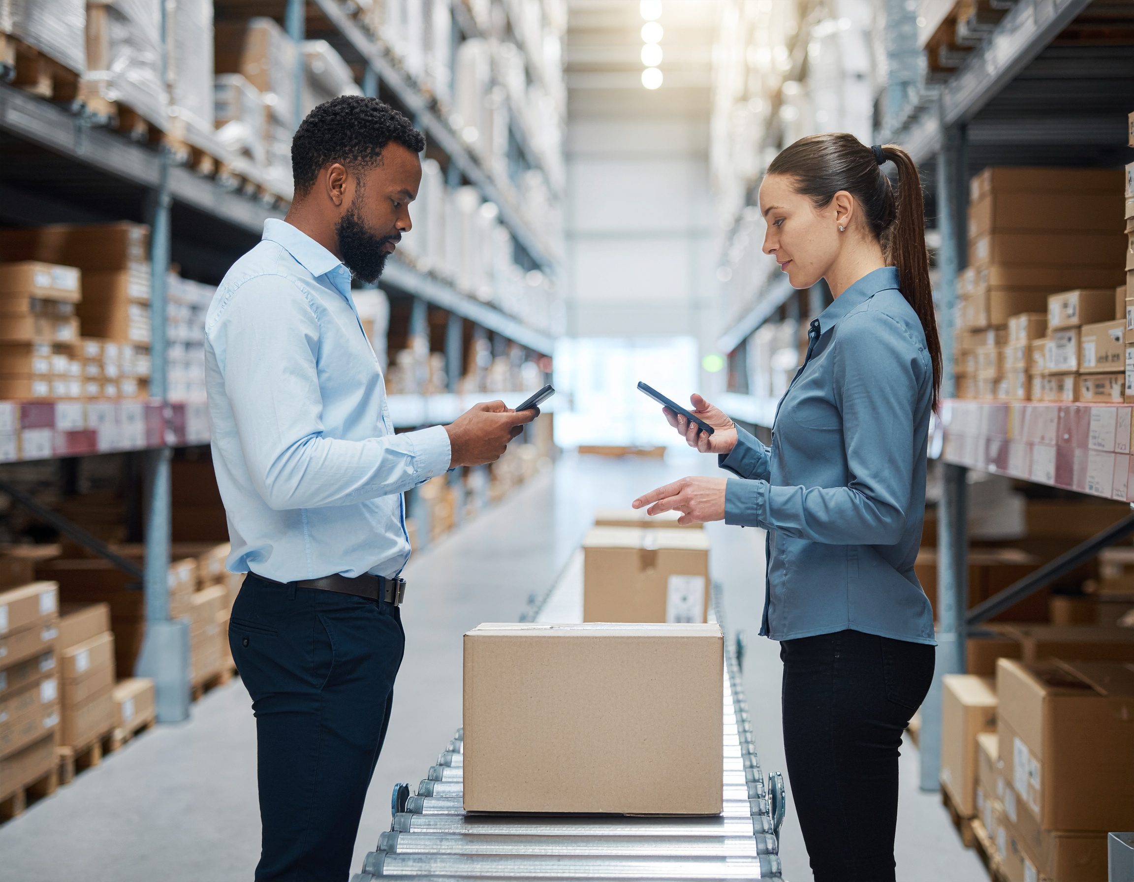 Warehouse workers scanning packages using handheld devices, surrounded by boxes Logistics Buyer